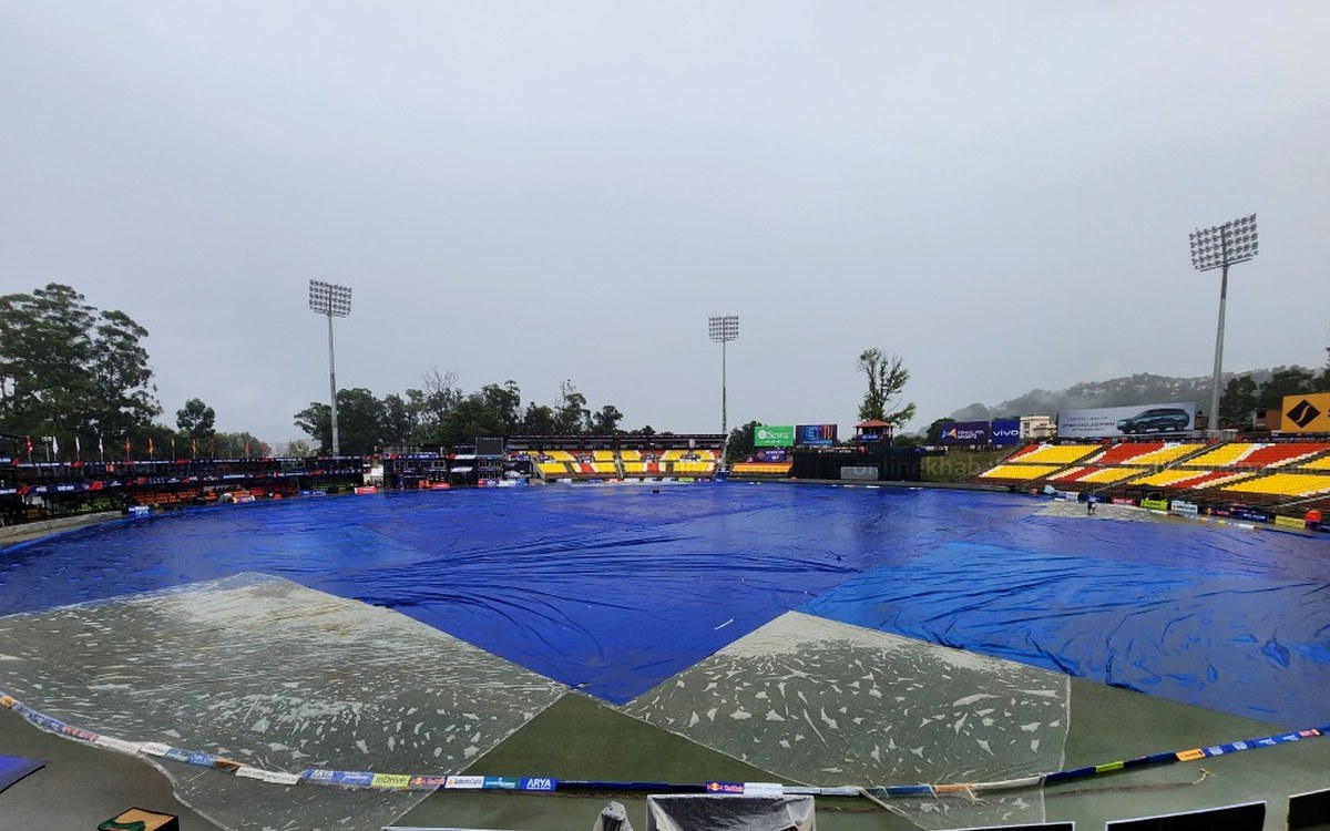 Blue covers over the waterlogged outfield at the TU Ground in Kirtipur under grey skies