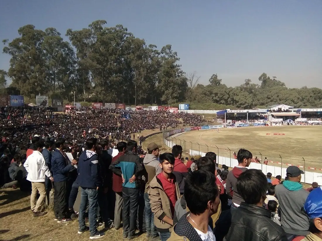 Fans packed on the grass banks at Tribhuvan University International Cricket Ground, Kirtipur, during a match